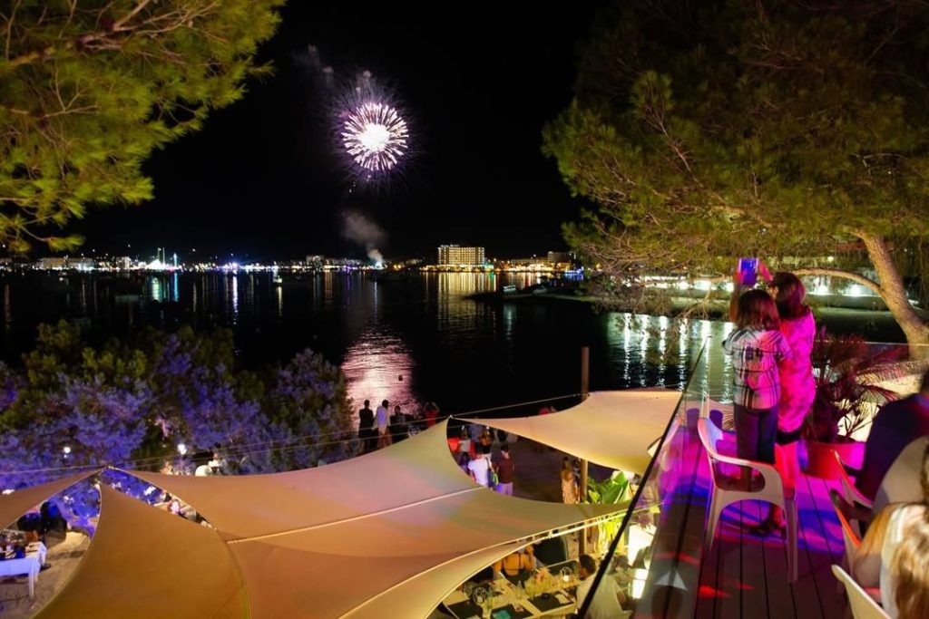 Fuegos artificiales sobre la bahía vistos desde The Beach de noche